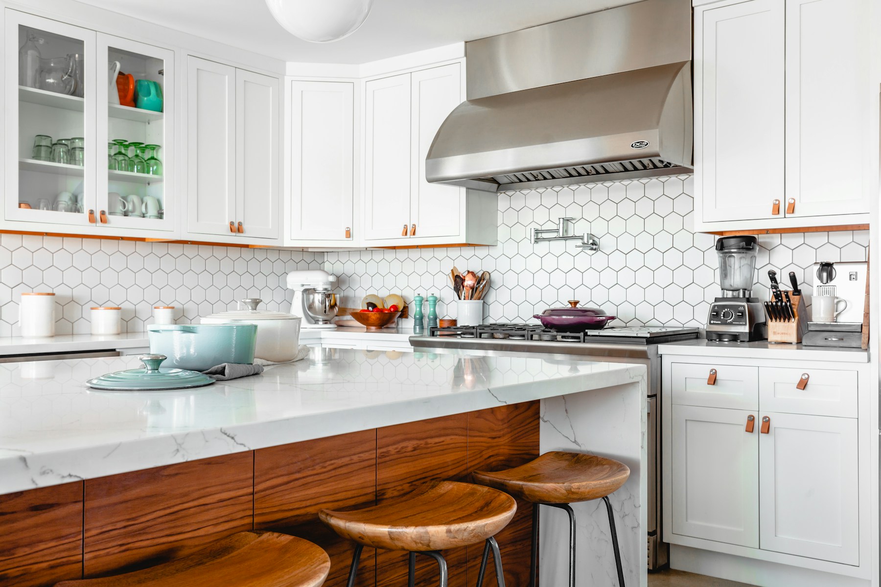 Cocina abierta con mobiliario claro y encimera de madera